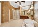 This bathroom features a tub, glass shower, vanity with double sinks, and decorative wallpaper at 5062 Stone Harbor Cir, Wimauma, FL 33598