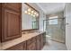 This bathroom features a glass shower, marble countertops, and wooden cabinetry at 5062 Stone Harbor Cir, Wimauma, FL 33598
