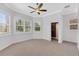 Bright bedroom featuring large windows, neutral carpet, ceiling fan and walk in closet at 5062 Stone Harbor Cir, Wimauma, FL 33598
