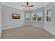 This bedroom features light walls, carpet, multiple windows with shutters, and a ceiling fan at 5062 Stone Harbor Cir, Wimauma, FL 33598