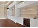 Custom built-in shelving and storage with accent lighting, cabinets, and a beverage refrigerator at 5062 Stone Harbor Cir, Wimauma, FL 33598