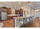 Gourmet kitchen boasts an island with bar seating, pendant lighting, stainless appliances, and ample counter space at 5062 Stone Harbor Cir, Wimauma, FL 33598