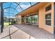 A view of the large, screened-in lanai that connects the interior to the view of the backyard pond at 5062 Stone Harbor Cir, Wimauma, FL 33598