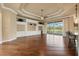Spacious living room with wood floors, custom built-ins, and expansive windows with views of the outdoors at 5062 Stone Harbor Cir, Wimauma, FL 33598