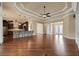Open floor plan featuring a large living room with hardwood floors connecting to the gourmet kitchen and entryway at 5062 Stone Harbor Cir, Wimauma, FL 33598