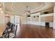 Open-concept space with wood floors, ceiling fan, bar-style seating, and custom built-in shelving at 5062 Stone Harbor Cir, Wimauma, FL 33598