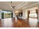 Expansive living area with hardwood floors, ceiling fan, backyard view, and bar seating to the kitchen at 5062 Stone Harbor Cir, Wimauma, FL 33598