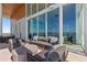 Exterior patio with waterfront views, stylish furniture, and floor-to-ceiling windows at 1020 Sunset Point Rd # 703, Clearwater, FL 33755