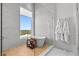 Bright bathroom featuring a soaking tub by a large window and a glass-enclosed shower with marble tile at 1020 Sunset Point Rd # 703, Clearwater, FL 33755