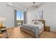 Bright bedroom with a chandelier, a large window, and hardwood floors with a decorative neutral color palette at 1020 Sunset Point Rd # 703, Clearwater, FL 33755