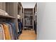 Walk-in closet featuring custom shelving, wooden floors, and ample storage for clothes and accessories at 1020 Sunset Point Rd # 703, Clearwater, FL 33755