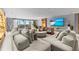 Spacious living room with plush seating, outdoor views, and a large-screen TV at 1020 Sunset Point Rd # 703, Clearwater, FL 33755