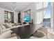 Bright living room featuring a large tv, comfortable seating, and floor-to-ceiling windows with water views at 1020 Sunset Point Rd # 703, Clearwater, FL 33755