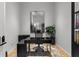 Home office with black desk, ergonomic chair, decorative mirror, and a leafy potted plant at 1020 Sunset Point Rd # 703, Clearwater, FL 33755