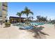 Serene swimming pool featuring lounge chairs and tropical trees, creating a tranquil and inviting outdoor space at 1020 Sunset Point Rd # 703, Clearwater, FL 33755