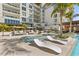 Stunning swimming pool with modern lounge chairs and lush tropical landscaping offering a resort-like experience at 1020 Sunset Point Rd # 703, Clearwater, FL 33755