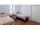 Bright bedroom with two twin beds with floral bedding and hard wood flooring at 10214 Garden Alcove Dr, Tampa, FL 33647