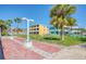 A view of the condo grounds including palm trees, lounge chairs, a shuffleboard court, and condo buildings at 11730 Gulf Blvd # 5, Treasure Island, FL 33706