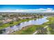 Aerial view showcases a community by the water, framed by lush landscaping and golf course at 1219 Huntington Greens Dr, Sun City Center, FL 33573