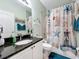 Bathroom featuring a decorative shower curtain, granite counters, and nautical decor for a stylish, coordinated look at 1219 Huntington Greens Dr, Sun City Center, FL 33573