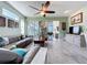 Bright living room featuring tile flooring, a ceiling fan, and sliding glass doors to the lanai at 1219 Huntington Greens Dr # 1219, Sun City Center, FL 33573