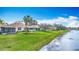 Waterfront homes feature lush lawns, screened lanais, and beautiful landscaping along the peaceful lake at 1219 Huntington Greens Dr, Sun City Center, FL 33573