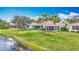 Landscaped home exterior with a manicured lawn and lake view at 1219 Huntington Greens Dr, Sun City Center, FL 33573