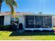 An outdoor grill sits outside the lanai of this well-maintained home with lush landscaping at 1219 Huntington Greens Dr, Sun City Center, FL 33573