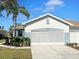 Charming single-story home with a well-manicured lawn and a beautiful palm tree in the front yard at 1219 Huntington Greens Dr, Sun City Center, FL 33573