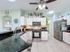 Updated kitchen boasts stainless steel appliances, sleek countertops, and white cabinets with an attached eat-in counter at 1219 Huntington Greens Dr, Sun City Center, FL 33573