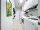 Convenient laundry room includes cabinetry, shelving, washer, and dryer at 1219 Huntington Greens Dr, Sun City Center, FL 33573