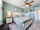 Comfortable main bedroom with a ceiling fan, a bathroom en suite, and wood-look flooring at 1219 Huntington Greens Dr, Sun City Center, FL 33573