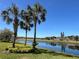 A picturesque pond sits behind several buildings on a sunny day at 1219 Huntington Greens Dr, Sun City Center, FL 33573