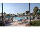 Community pool area with lounge chairs and palm trees offers a relaxing resort-style atmosphere at 1219 Huntington Greens Dr, Sun City Center, FL 33573