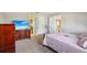 Spacious bedroom with a flatscreen TV, and views of the connected bathroom and kitchen at 12503 Willow Tree Ave, Hudson, FL 34669