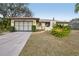 Charming single-story home with landscaped front yard, attached garage, and inviting courtyard entryway at 12503 Willow Tree Ave, Hudson, FL 34669