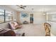 Spacious living room with plush carpeting, ceiling fan, and ample natural light at 12503 Willow Tree Ave, Hudson, FL 34669