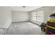 Well-lit living room with soft carpet, a large window and some storage containers at 12503 Willow Tree Ave, Hudson, FL 34669