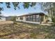 View of home's back exterior with fenced yard and enclosed porch at 12503 Willow Tree Ave, Hudson, FL 34669