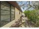 A close up of the side of the house, with a sidewalk and lush foliage at 12503 Willow Tree Ave, Hudson, FL 34669
