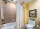 Bathroom featuring a tub and shower with stone tile, and a toilet with beach decor at 1590 Gulf Blvd # 501, Clearwater Beach, FL 33767