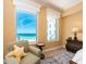 Cozy bedroom showcasing a comfortable chair and a window with serene ocean views and a traditional accent rug at 1590 Gulf Blvd # 501, Clearwater Beach, FL 33767