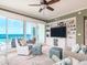Comfortable living room featuring plush seating, built-in shelving, and stunning ocean views through large glass doors at 1590 Gulf Blvd # 501, Clearwater Beach, FL 33767