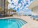 Close up view of a pool with steps, palm trees, and clear blue sky at 1590 Gulf Blvd # 501, Clearwater Beach, FL 33767