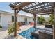 Backyard patio features a pergola, brick pavers, a cozy seating area and lush tropical plants, perfect for outdoor entertaining at 1782 Coconut Dr, Venice, FL 34293