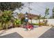 Backyard patio features a pergola, brick pavers, a cozy seating area and lush tropical plants, creating a relaxing outdoor oasis at 1782 Coconut Dr, Venice, FL 34293