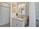 Bright bathroom featuring a granite countertop, white cabinets, and neutral decor at 1782 Coconut Dr, Venice, FL 34293