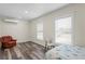 Cozy bedroom features a light blue bedspread, dark flooring, and a bright double window at 1782 Coconut Dr, Venice, FL 34293