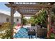 Outdoor pergola with seating area on a patterned blue rug in a tropical backyard at 1782 Coconut Dr, Venice, FL 34293