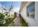 Side yard features a brick paver pathway, lush landscaping and a pristine white fence creating a charming and private outdoor space at 1782 Coconut Dr, Venice, FL 34293